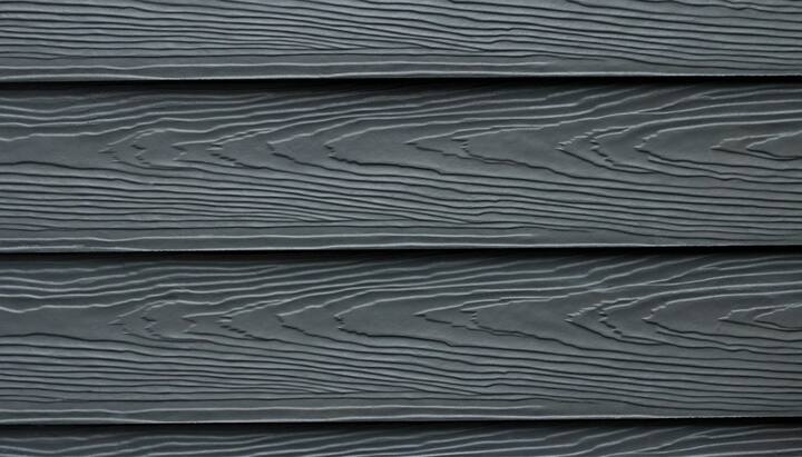 Beautiful grey fiber cement siding with natural looking wood grain installed on an older home.